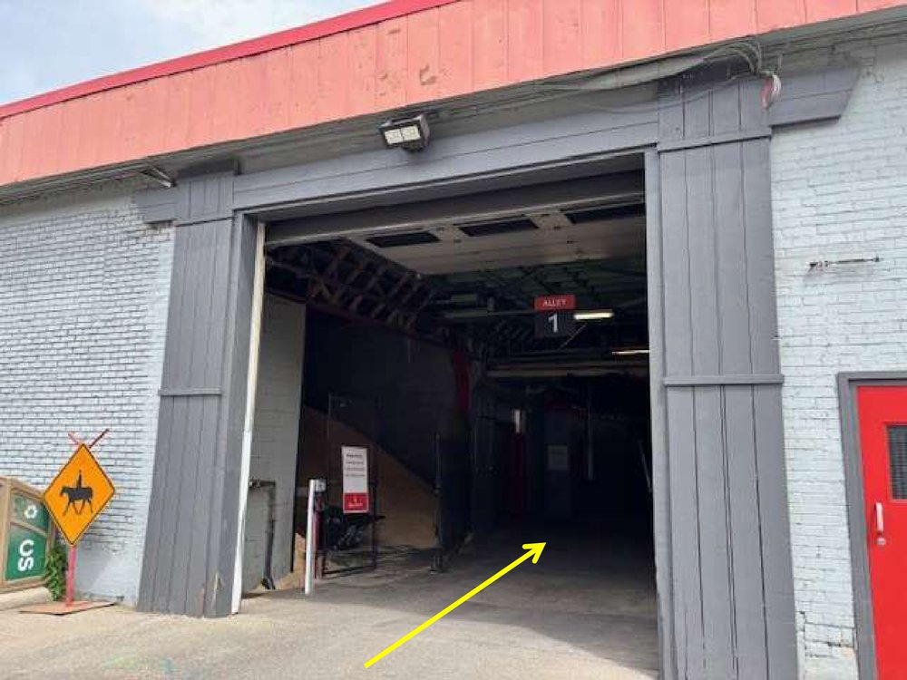 The Alley 1 entrance, a large open doorway with the Alley 1 sign overhead and a red door on the right.